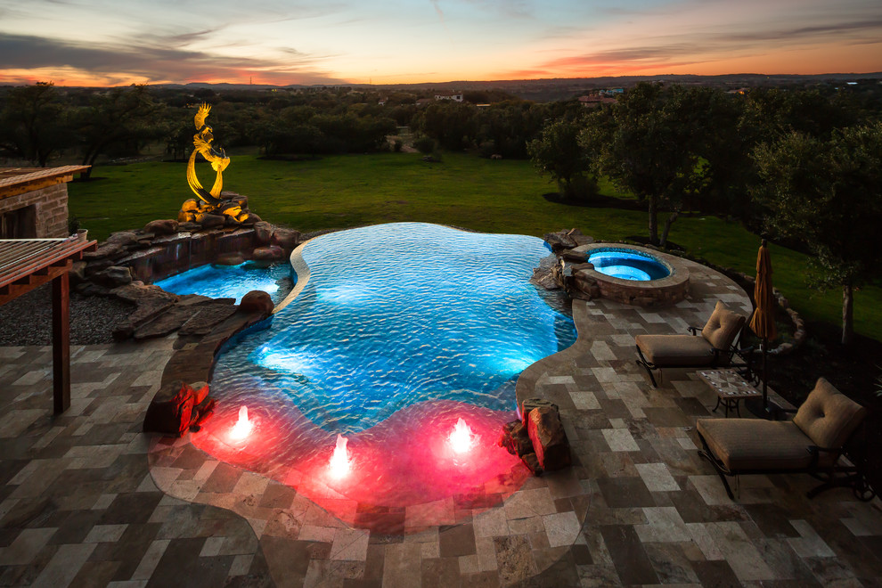 Example of a huge classic backyard stone and custom-shaped infinity pool design in Austin
