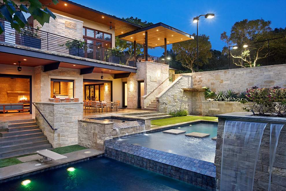 Immagine di una grande piscina monocorsia contemporanea rettangolare dietro casa con una vasca idromassaggio e piastrelle