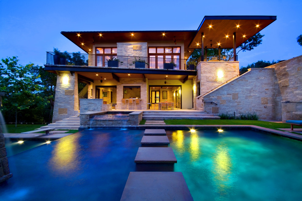 Inspiration for a large contemporary backyard custom-shaped and stone lap pool remodel in Austin