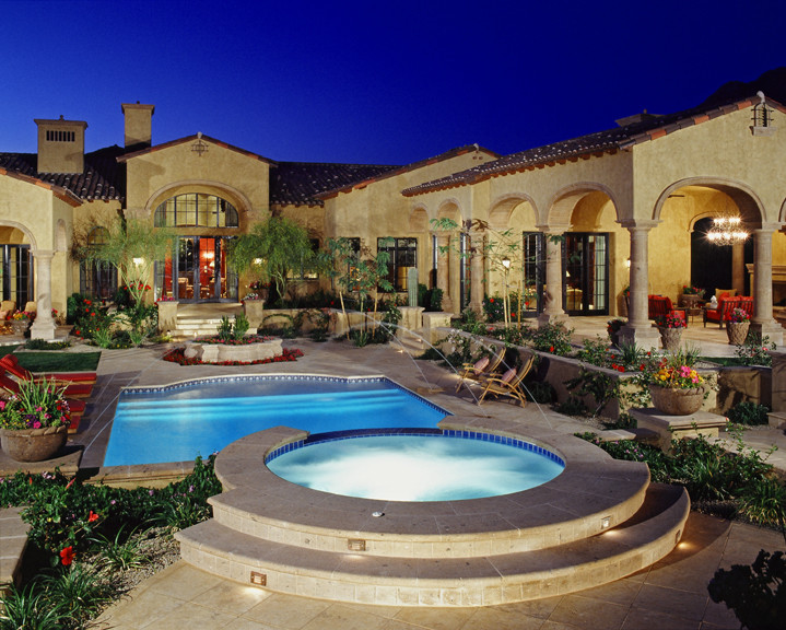 Diseño de piscina con fuente alargada tradicional extra grande rectangular en patio trasero con adoquines de piedra natural