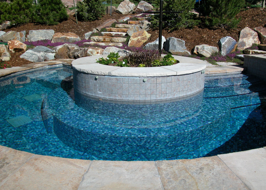 Cette image montre une petite piscine naturelle et arrière sur mesure avec un bain bouillonnant et des pavés en pierre naturelle.