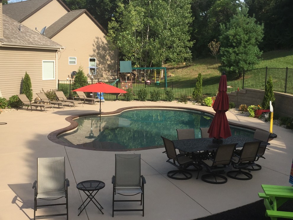 Foto di una piscina naturale classica personalizzata dietro casa e di medie dimensioni con cemento stampato