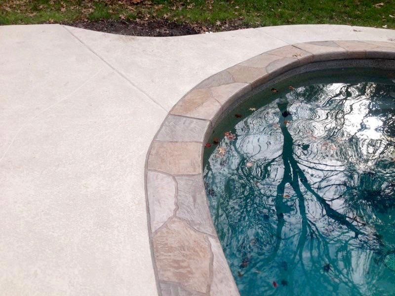 Mid-sized elegant backyard stamped concrete and custom-shaped natural pool photo in St Louis