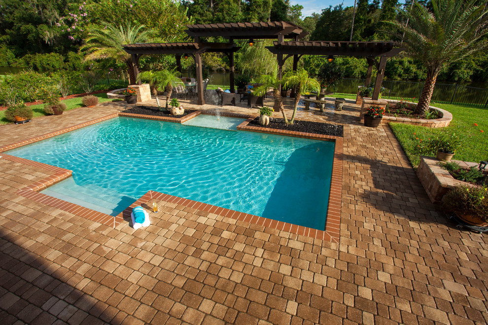 Modelo de piscina con fuente elevada clásica extra grande rectangular en patio trasero con adoquines de piedra natural