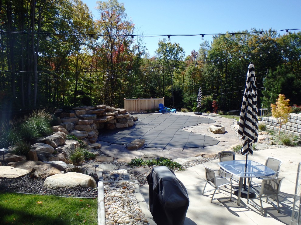 Inspiration for a timeless backyard stamped concrete and custom-shaped natural pool fountain remodel in Philadelphia