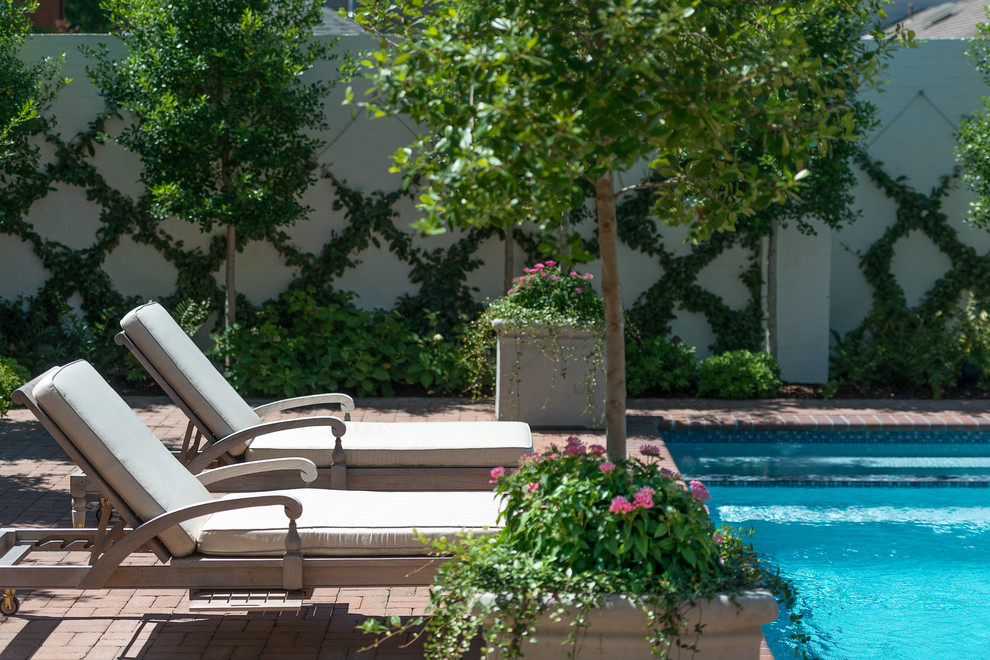 Ejemplo de piscina alargada tradicional de tamaño medio rectangular en patio trasero con adoquines de ladrillo