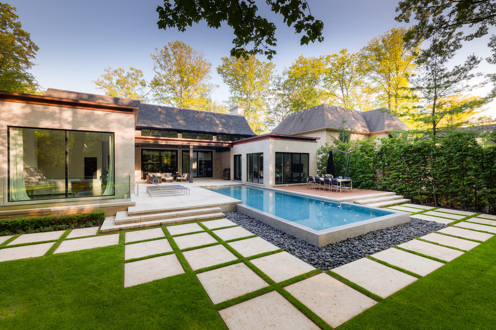 Ispirazione per una grande piscina a sfioro infinito minimal rettangolare dietro casa con fontane e pavimentazioni in pietra naturale