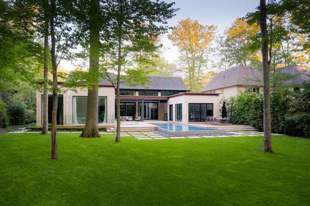Großer Moderner Infinity-Pool hinter dem Haus in rechteckiger Form mit Wasserspiel und Natursteinplatten in Sonstige