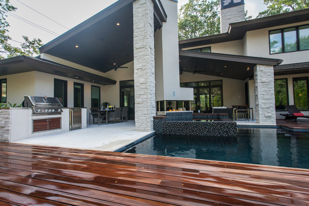 Idee per una grande piscina naturale design personalizzata dietro casa con una vasca idromassaggio e pedane