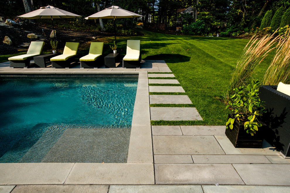 Ejemplo de piscina contemporánea de tamaño medio rectangular con adoquines de piedra natural