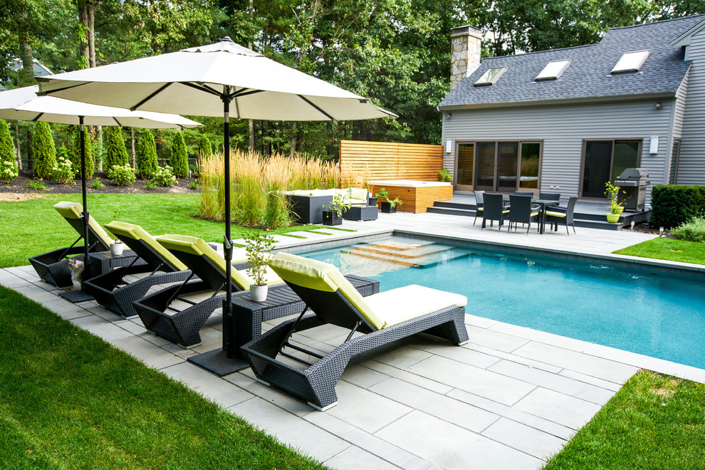 Aménagement d'une piscine contemporaine de taille moyenne et rectangle avec des pavés en pierre naturelle.