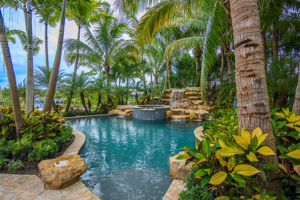 Foto di una grande piscina tropicale personalizzata con fontane