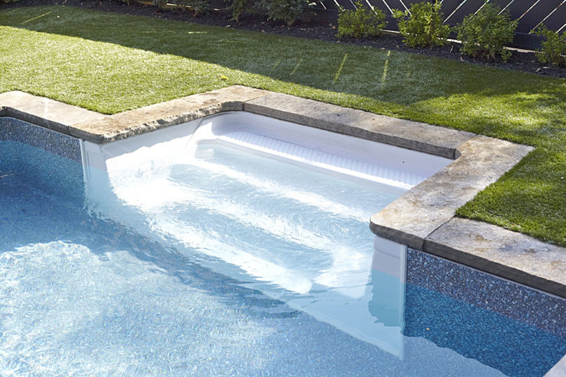 Cette photo montre une grande piscine naturelle et arrière tendance en L avec un point d'eau et des pavés en pierre naturelle.