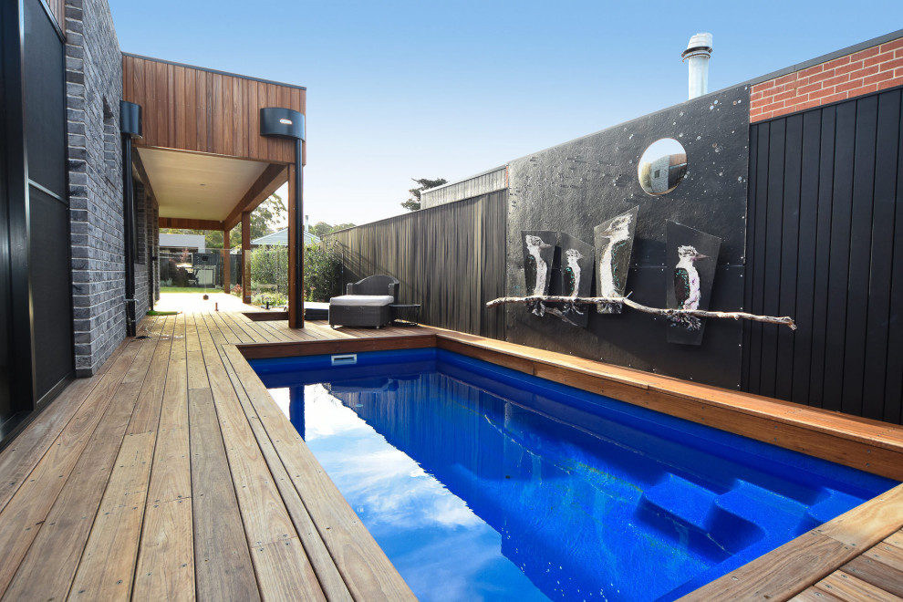 Ejemplo de piscina alargada contemporánea de tamaño medio rectangular en patio lateral