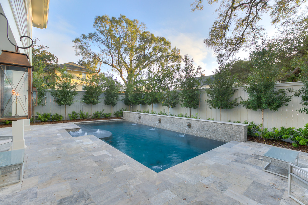 Diseño de piscina con fuente alargada clásica renovada rectangular en patio trasero con adoquines de piedra natural