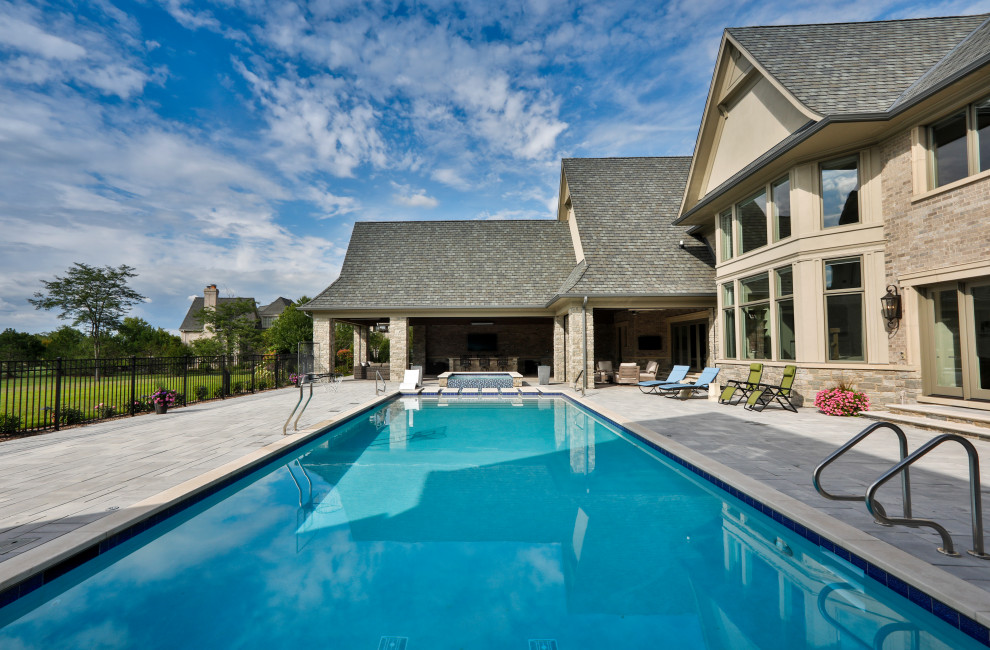 На фото: спортивный, прямоугольный ландшафтный бассейн среднего размера на заднем дворе в классическом стиле с покрытием из каменной брусчатки