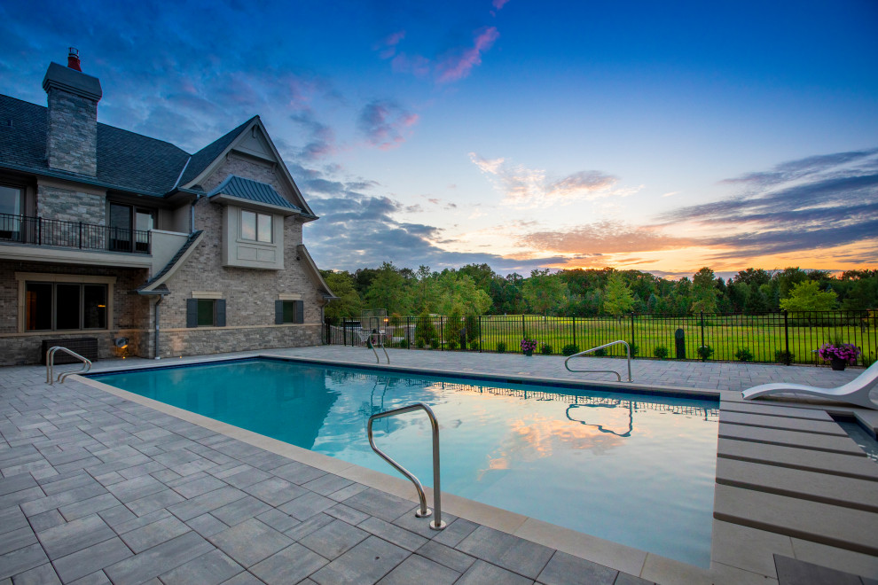 Immagine di una piscina monocorsia tradizionale rettangolare di medie dimensioni e dietro casa con paesaggistica bordo piscina e pavimentazioni in pietra naturale