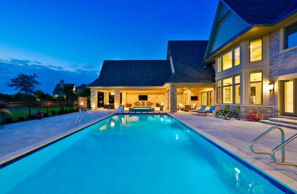 Foto di una piscina monocorsia classica rettangolare di medie dimensioni e dietro casa con paesaggistica bordo piscina e pavimentazioni in pietra naturale