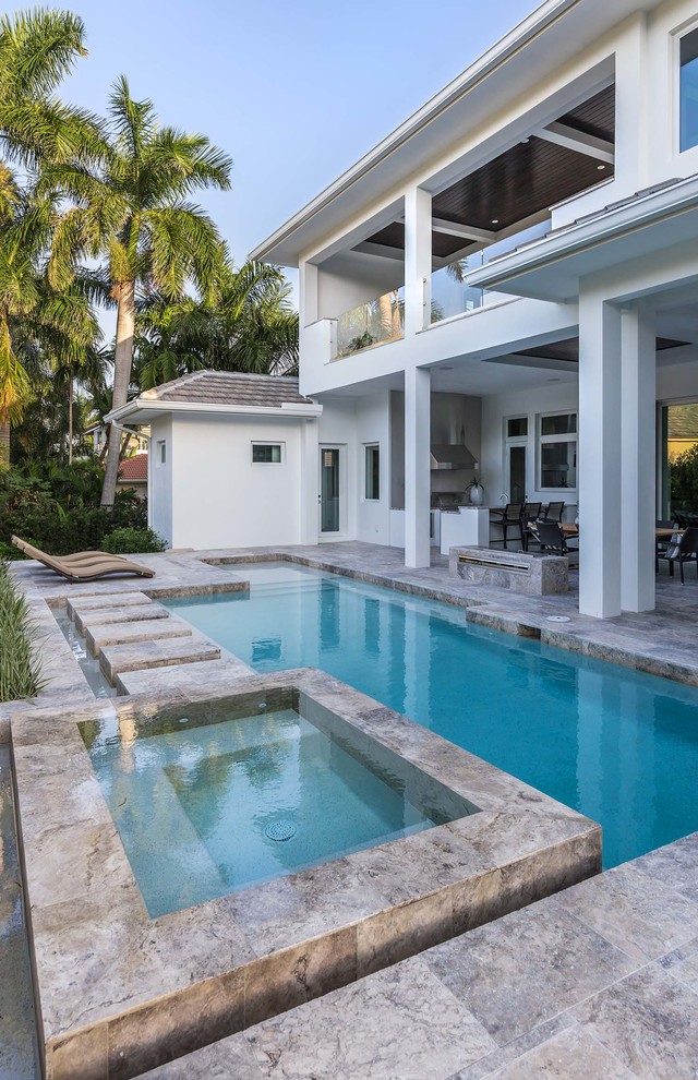 Immagine di una grande piscina costiera personalizzata dietro casa con pavimentazioni in cemento