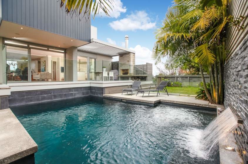 Moderner Pool hinter dem Haus in individueller Form mit Betonplatten in Auckland