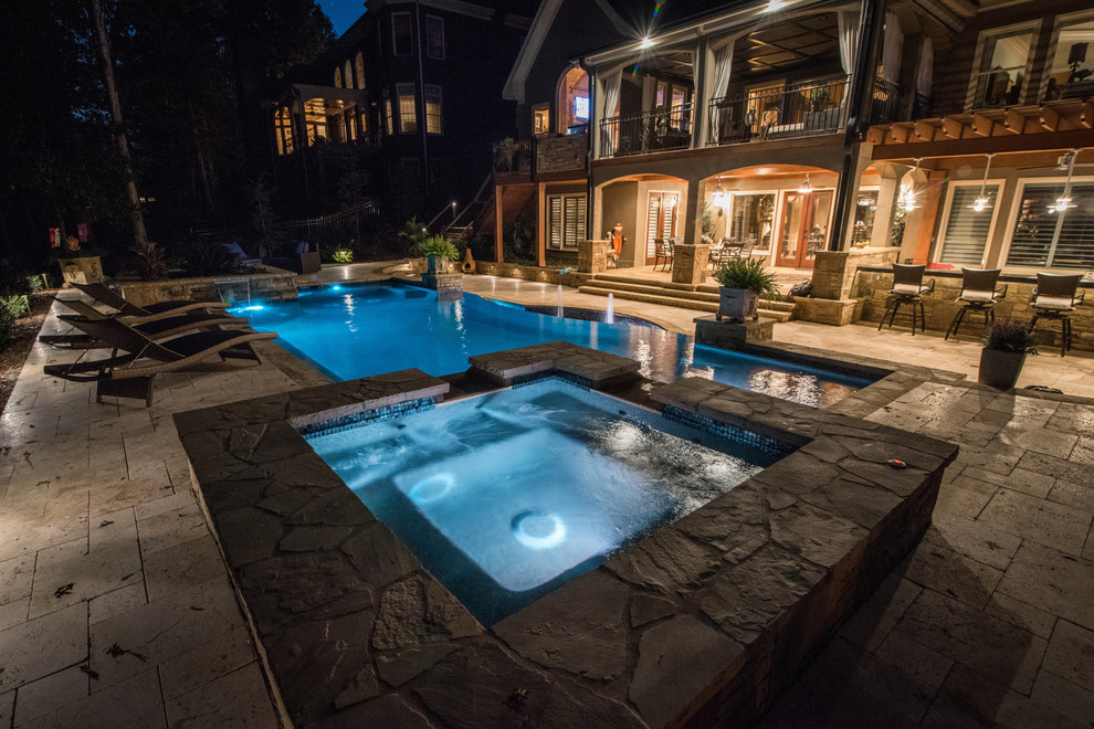 Example of a large classic backyard custom-shaped infinity pool fountain design in Atlanta with decking