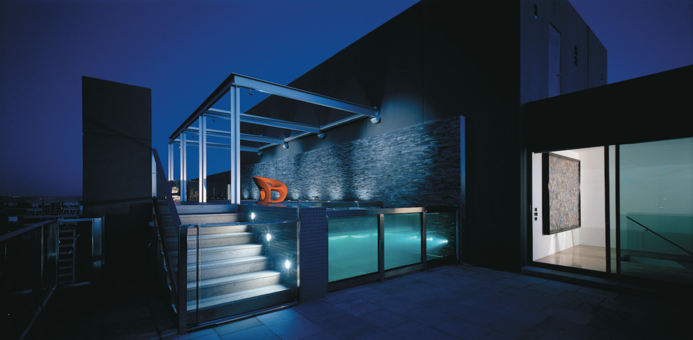 Idée de décoration pour une piscine sur toit hors-sol minimaliste de taille moyenne et rectangle avec une terrasse en bois.