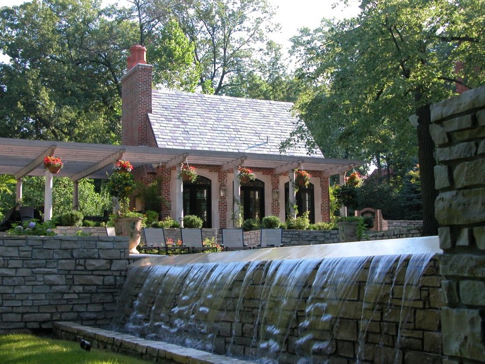 Foto de piscina con fuente infinita tradicional grande rectangular en patio trasero con adoquines de hormigón