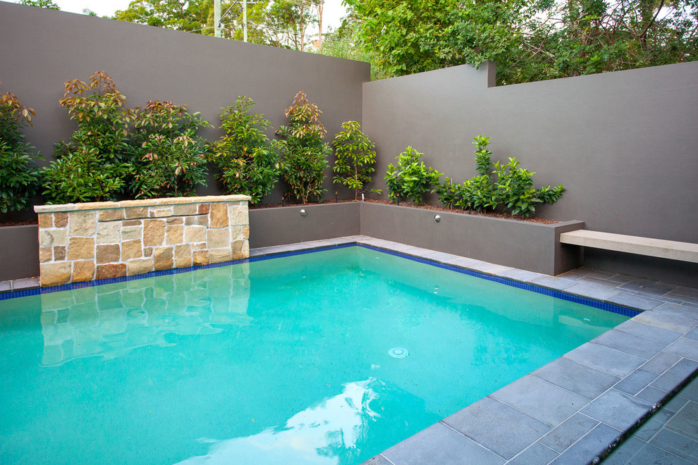 Mittelgroßer Moderner Pool in rechteckiger Form mit Wasserspiel und Natursteinplatten in Brisbane
