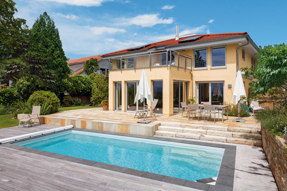 Immagine di una piscina monocorsia mediterranea rettangolare di medie dimensioni e dietro casa con pedane