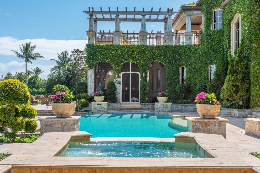 На фото: естественный бассейн на заднем дворе в средиземноморском стиле с джакузи с