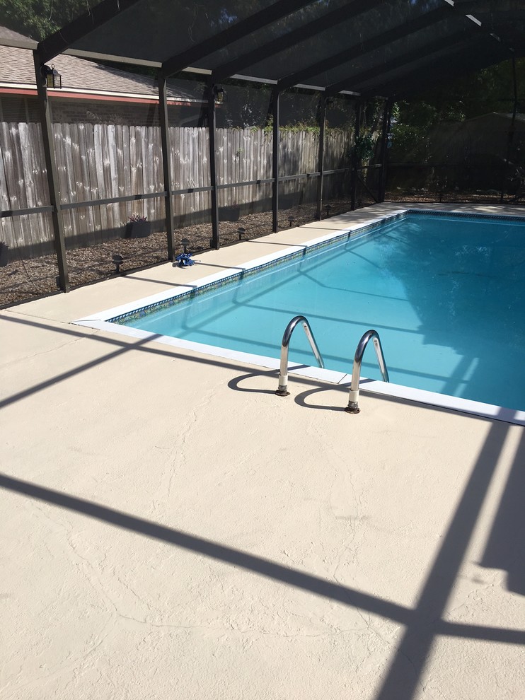 Imagen de piscina contemporánea extra grande rectangular en patio trasero con losas de hormigón