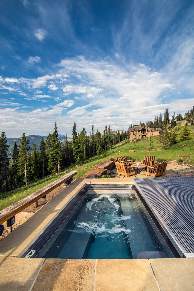 Example of a mountain style tile and rectangular hot tub design