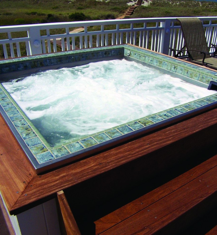 Cette image montre une petite piscine hors-sol et arrière rectangle avec un bain bouillonnant et une terrasse en bois.