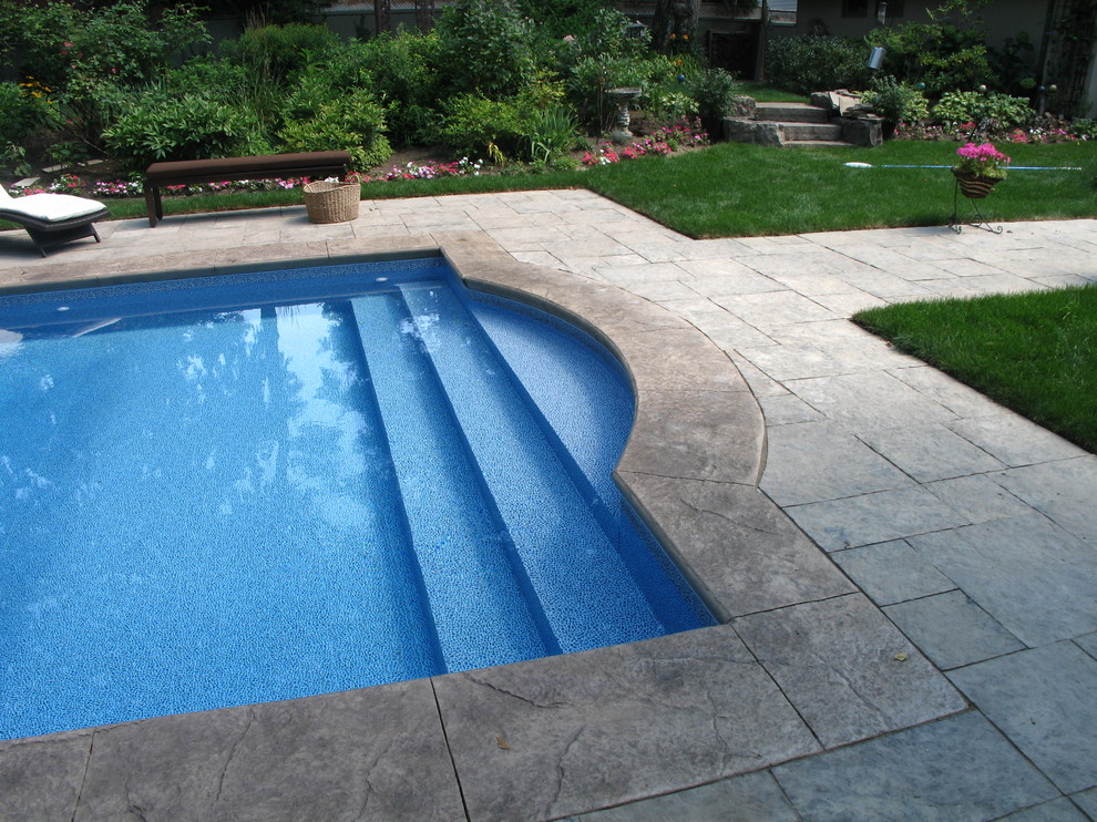 Идея дизайна: большой спортивный, прямоугольный бассейн на заднем дворе в стиле неоклассика (современная классика) с покрытием из каменной брусчатки