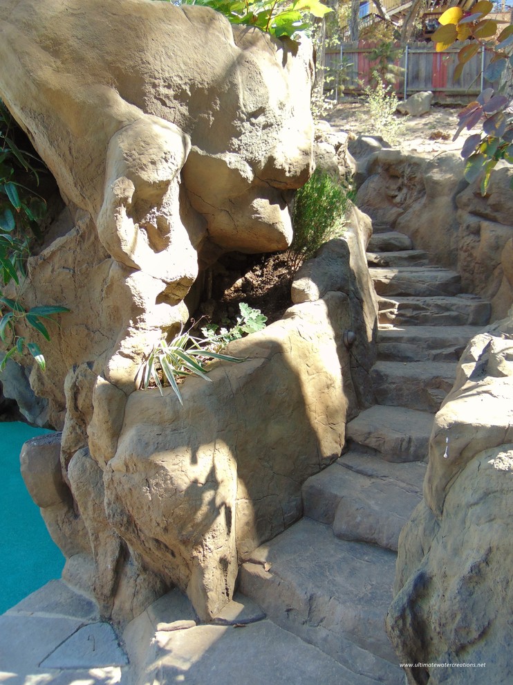 Esempio di una grande piscina naturale tropicale personalizzata dietro casa con un acquascivolo e pavimentazioni in pietra naturale