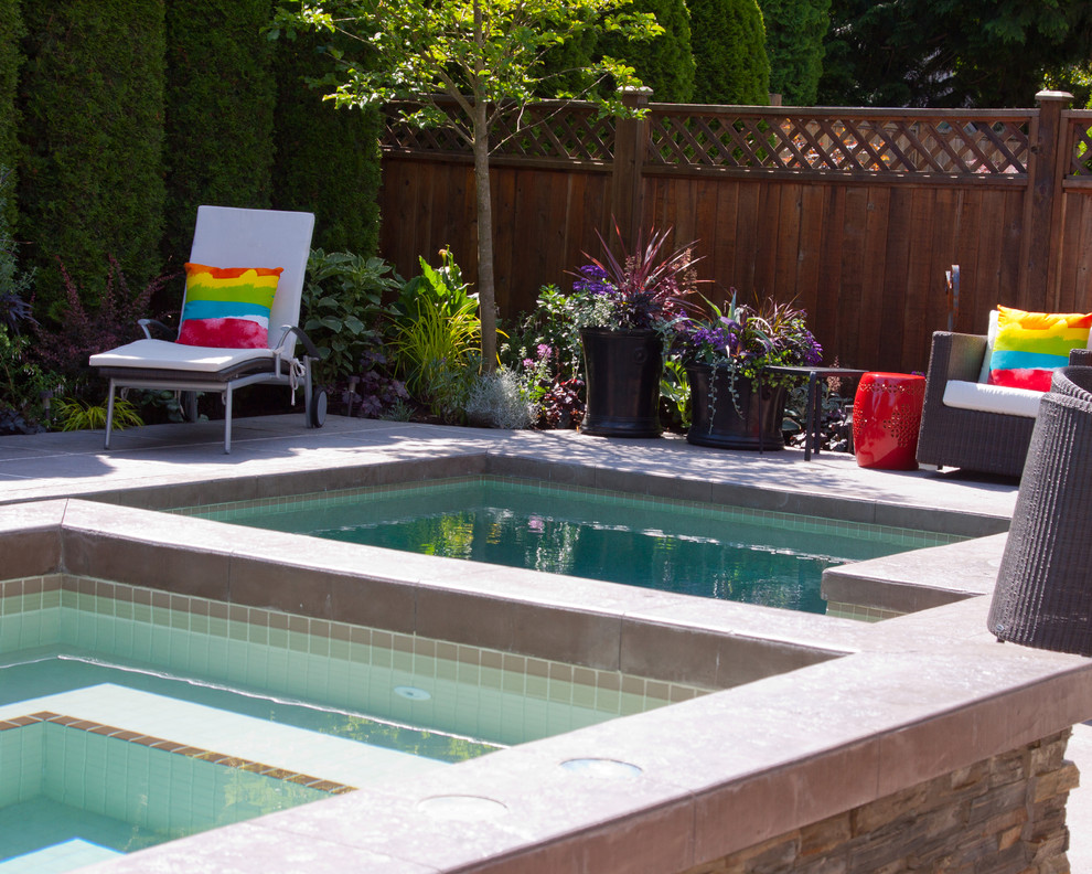 Photo of a contemporary back custom shaped hot tub in Vancouver with stamped concrete.