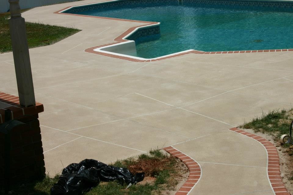 Imagen de casa de la piscina y piscina alargada clásica grande tipo riñón en patio trasero con suelo de hormigón estampado