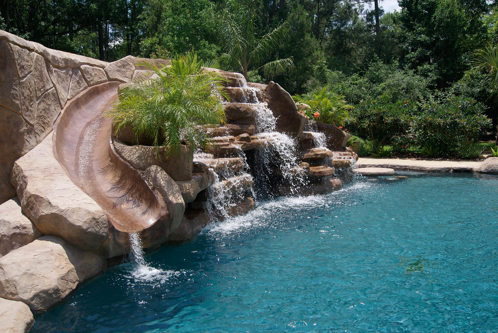 Cette image montre une piscine naturelle et arrière ethnique de taille moyenne et sur mesure avec un toboggan et du béton estampé.