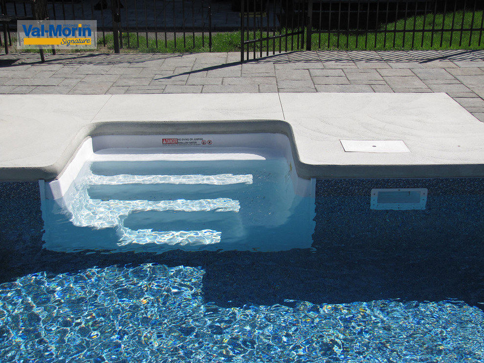 Idee per una piscina tradizionale rettangolare di medie dimensioni e dietro casa con fontane e pavimentazioni in cemento