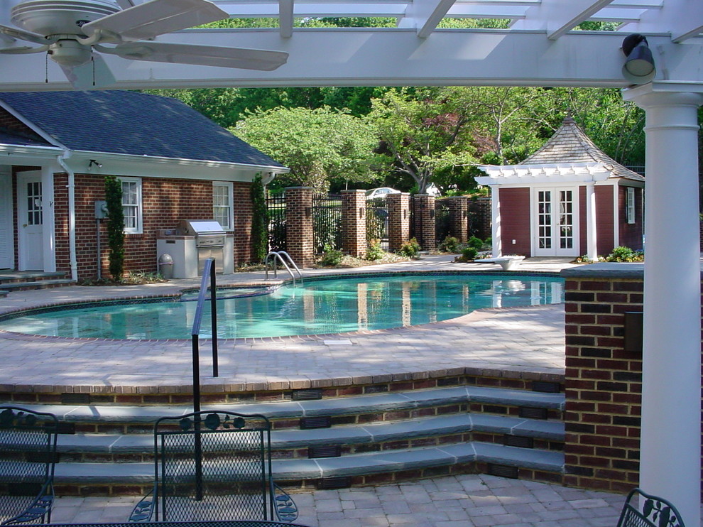 Idéer för stora vintage njurformad baddammar på baksidan av huset, med poolhus och marksten i tegel