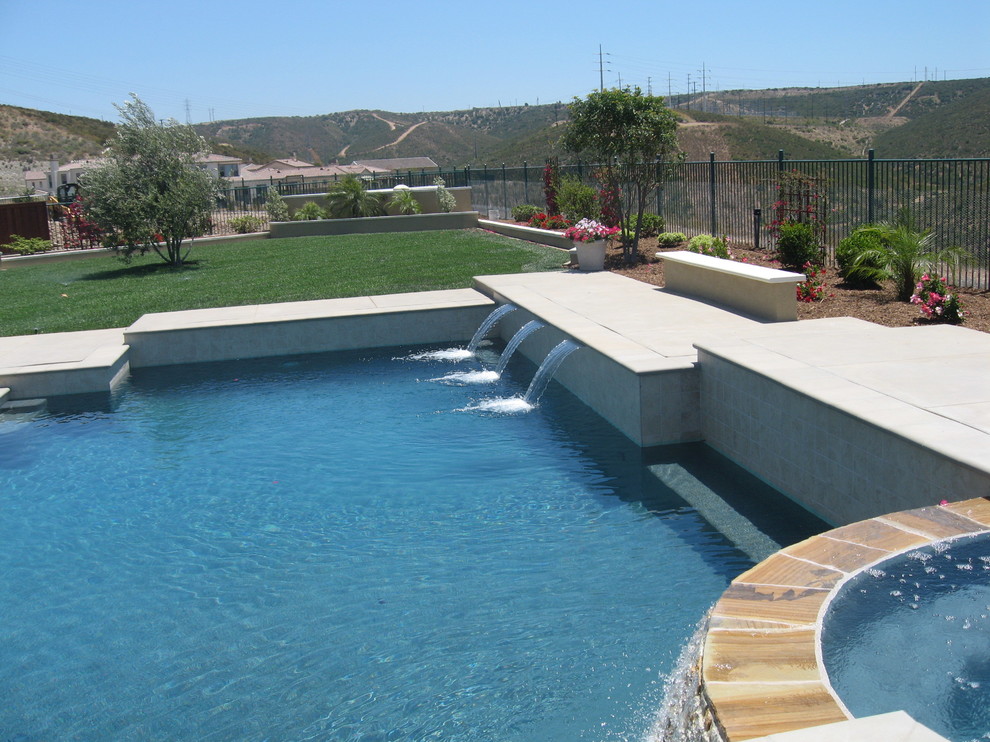 Idee per una piscina naturale moderna personalizzata di medie dimensioni e dietro casa con una vasca idromassaggio e lastre di cemento