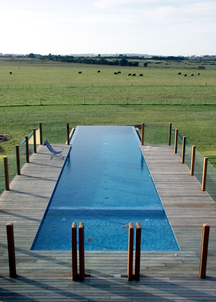 This is an example of a large contemporary front rectangular infinity swimming pool in Geelong with decking.