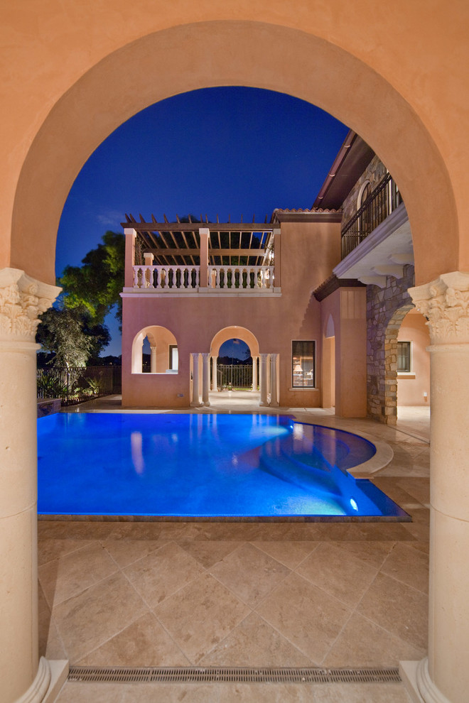 Exemple d'une grande piscine arrière méditerranéenne sur mesure avec du carrelage et un bain bouillonnant.
