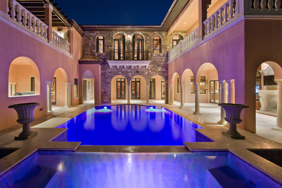 Immagine di una grande piscina mediterranea personalizzata dietro casa con piastrelle e una vasca idromassaggio