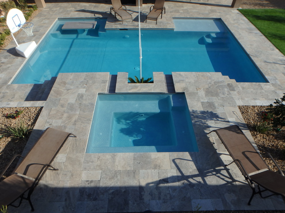Aménagement d'une piscine arrière moderne de taille moyenne et sur mesure avec un bain bouillonnant et des pavés en pierre naturelle.