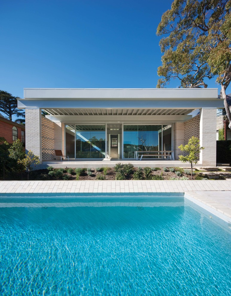 Foto de piscina elevada moderna rectangular con adoquines de ladrillo