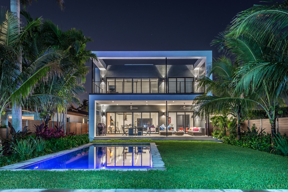 Photo of an expansive contemporary back rectangular swimming pool in Miami with concrete slabs.