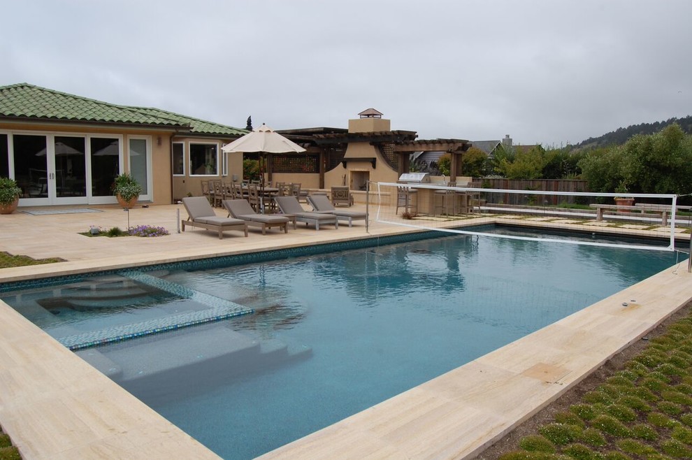 Esempio di una grande piscina mediterranea rettangolare dietro casa con una vasca idromassaggio e piastrelle
