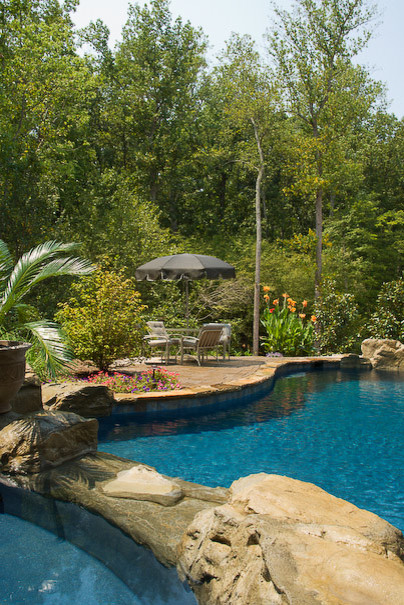Foto de piscinas y jacuzzis naturales tradicionales extra grandes a medida en patio trasero con adoquines de piedra natural