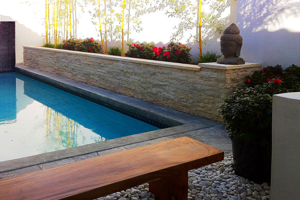 Esempio di una piscina monocorsia etnica rettangolare di medie dimensioni con pavimentazioni in pietra naturale